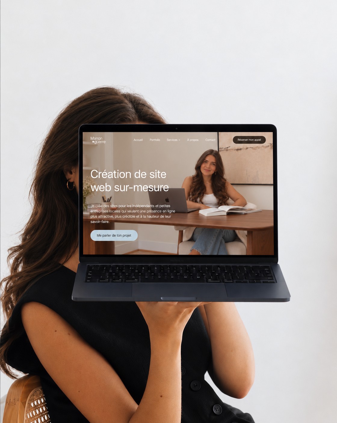 Manon tenant un ordinateur portable affichant un site web sur-mesure